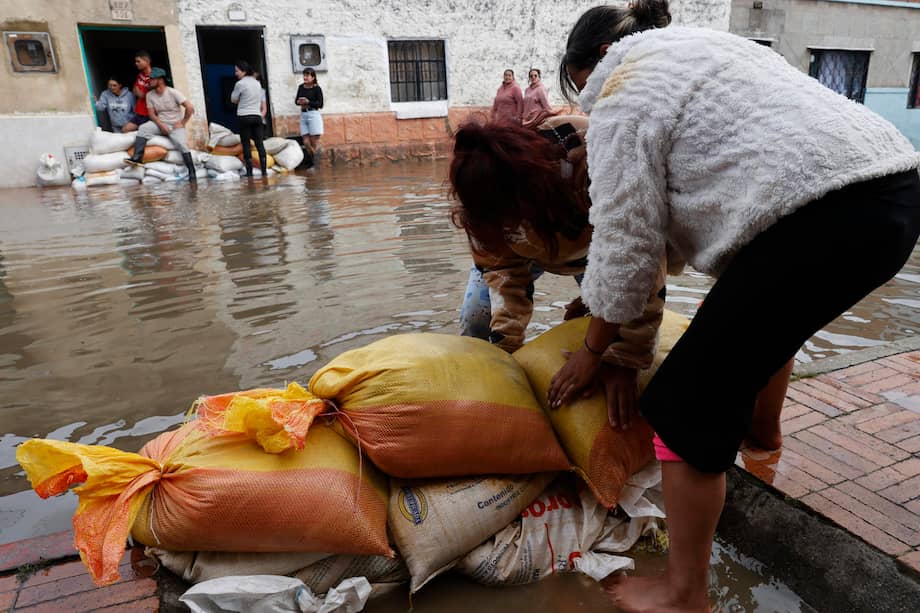 AME5640. FACATATIVÁ (COLOMBIA), 19/03/2026.- Personas usan sacos de arena para impedir que el agua entre a las casas debido a las inundaciones por fuertes lluvias este jueves, en Facatativá (Colombia). EFE/ Mauricio Dueñas Castañeda