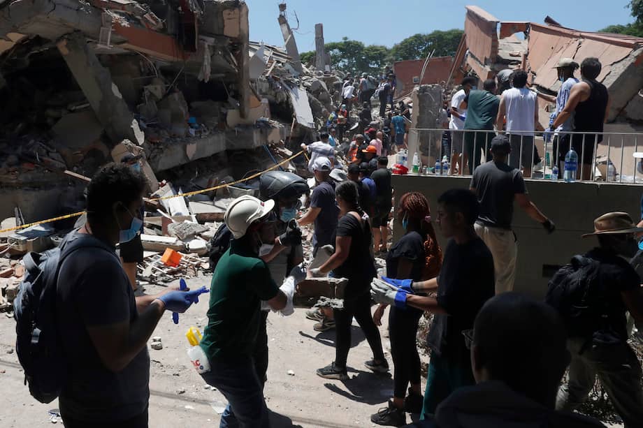 Personas buscan entre los escombros de una edificación colapsada por el terremoto de magnitud 7,4 que sacudió esta mañana al país, este lunes en Cali (Colombia).