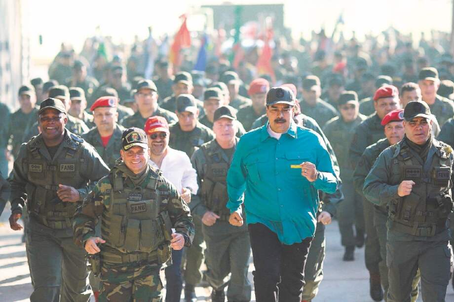 Nicolás Maduro marcha junto al ministro de la Defensa, Vladimir Padrino, durante ejercicios militares en Carabobo. / EFE