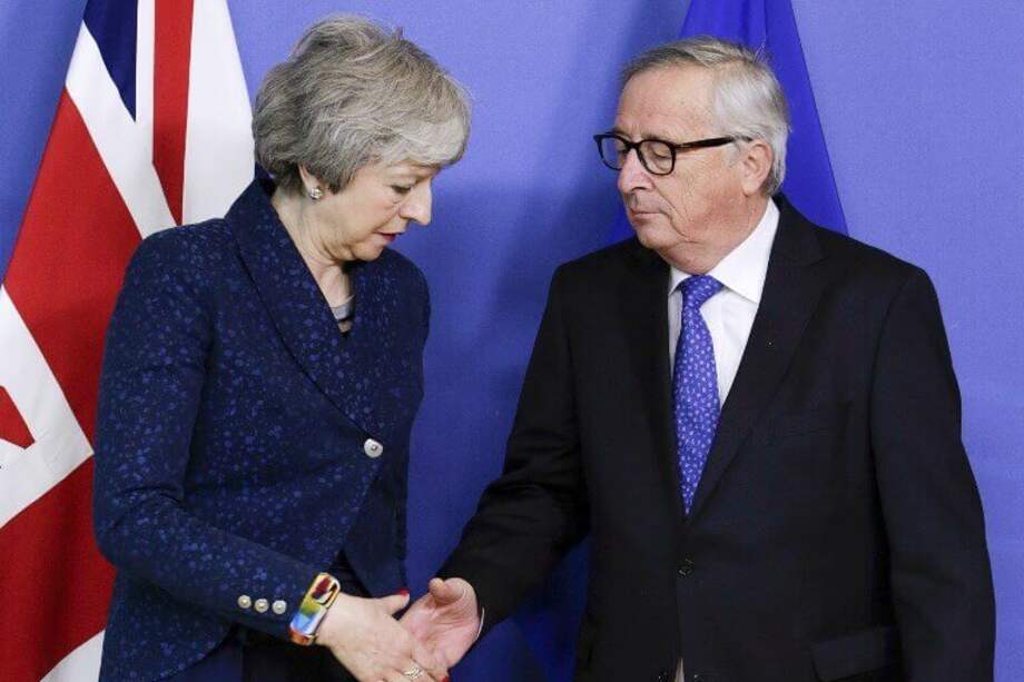Theresa May, primera ministra británica, saluda a Jean Claude Juncker, presidente de la Comisión Europea. / AFP