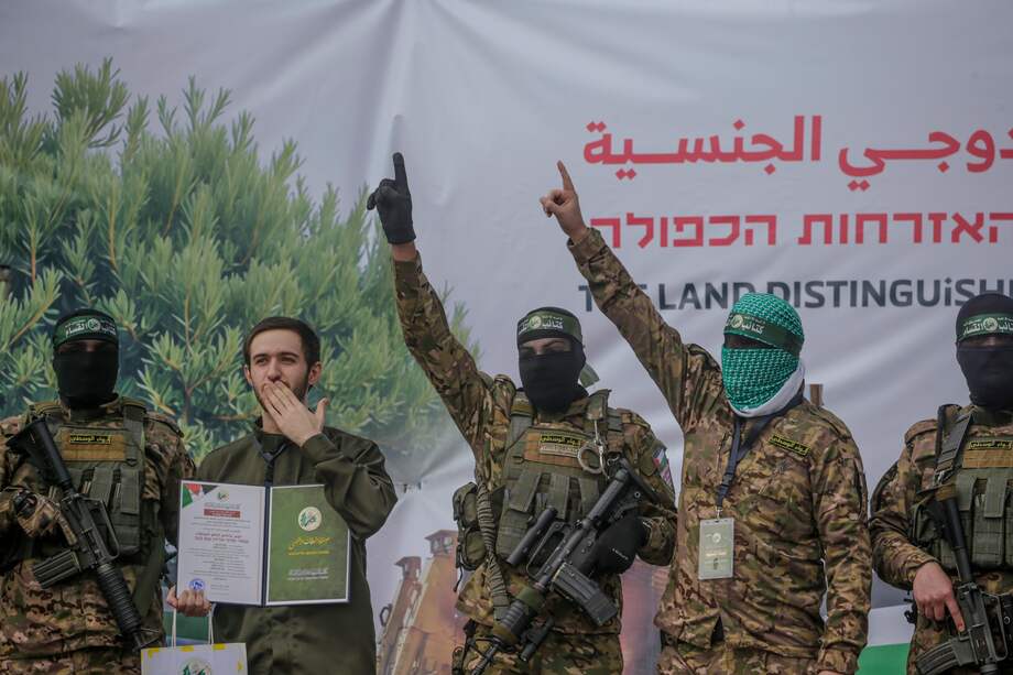 Combatientes de las Brigadas Izz ad-Din al-Qassam de Hamas escoltan al rehén israelí Omer Shem Tov antes de entregarlo a la Cruz Roja en el campo de refugiados de Al Nusairat, en el centro de la Franja de Gaza, el 22 de febrero de 2025.
