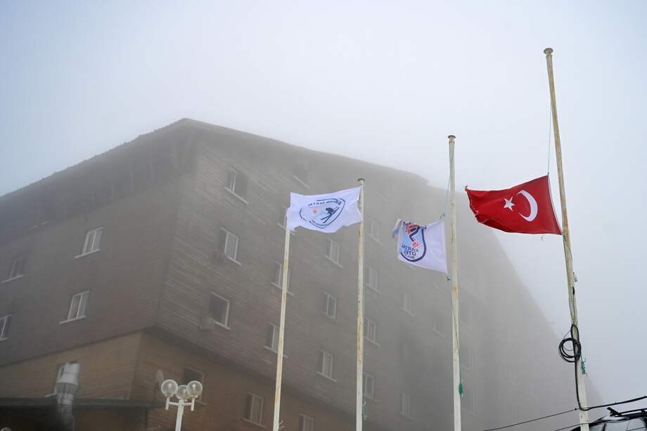 La bandera nacional ondea a media asta frente al hotel que se incendió en la estación de esquí Kartalkaya, en Bolu, Turquía.
