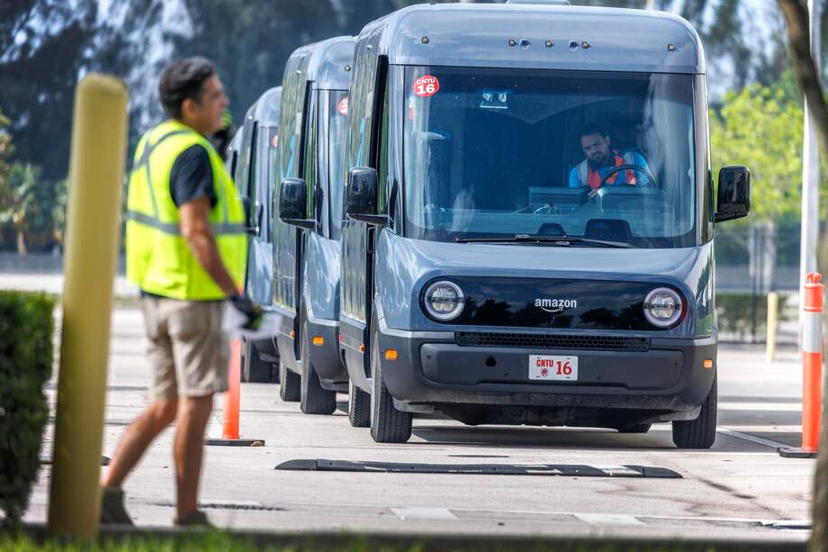 Un trabajador de Amazon revisa los camiones de Amazon afuera de la estación de entrega Amazon DMF5 en Miami, Florida, EE. UU., el 28 de abril de 2025.