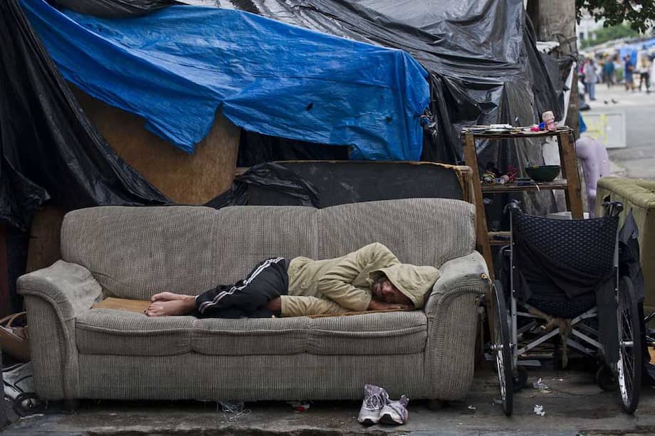 Un habitante de calle descansa en una calle de São Paulo, Brasil, país que ha avanzado en la reducción de la inequidad. / AFP