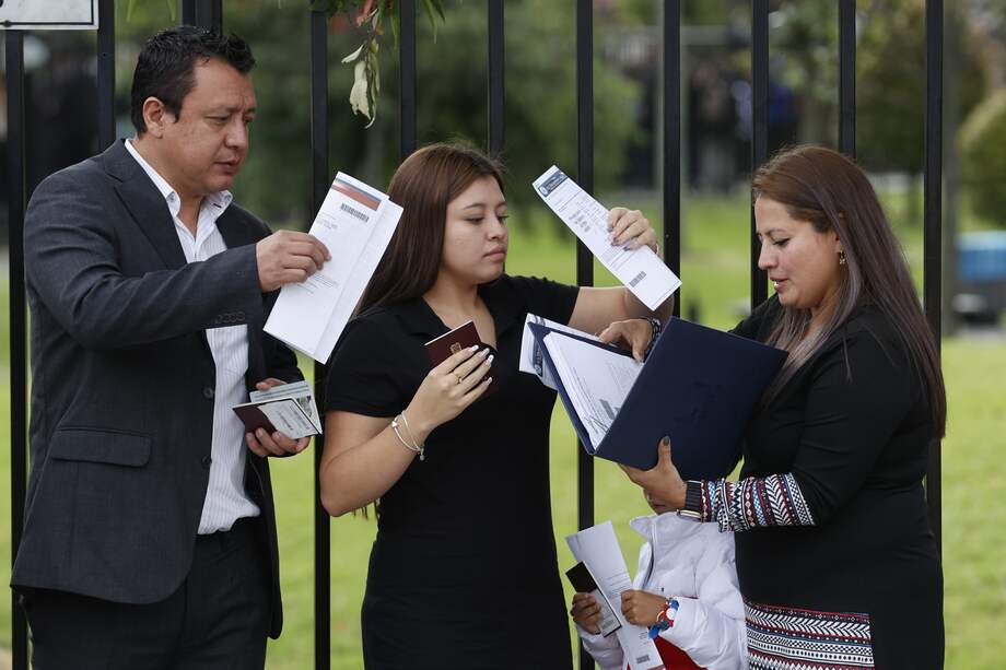 Ciudadanos colombianos ordenan documentos para solicitar la visa de los Estados Unidos , afuera de la embajada estadounidense en Bogotá (Colombia).