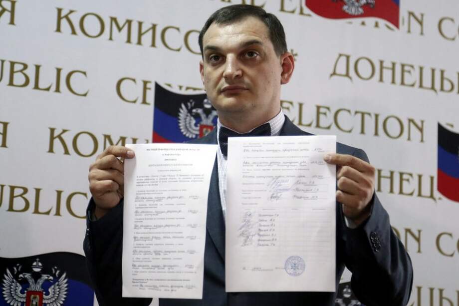 El jefe de la Comisión Electoral Central, Roman Lyagin, muestra los resultados del referéndum durante una rueda de prenda en Donetsk (Ucrania)