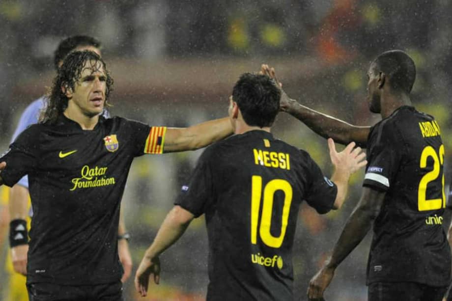 Carles Puyol, Lionel Messi y Eric Abidal, cuando jugaban juntos en el Barcelona. / AFP