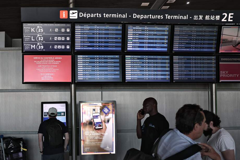 Los pasajeros miran el panel de información de salidas en el aeropuerto Roissy Charles-de-Gaulle, en las afueras de París, el 3 de julio de 2025.