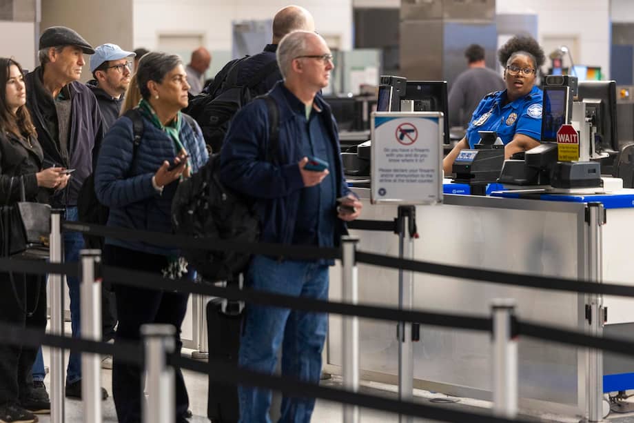 Agentes de la TSA revisan pasajeros en el Aeropuerto Nacional Reagan de Washington amid cierre parcial del gobierno y largas filas.