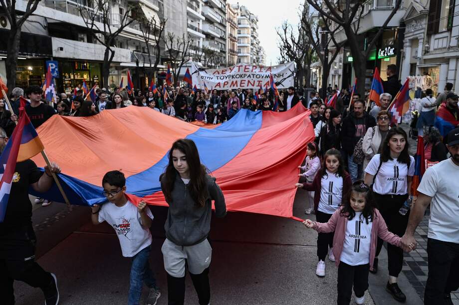Miembros de la comunidad armenia sostienen una bandera armenia gigante durante una manifestación para conmemorar el 110º aniversario del genocidio armenio, en Salónica, el 24 de abril de 2025.