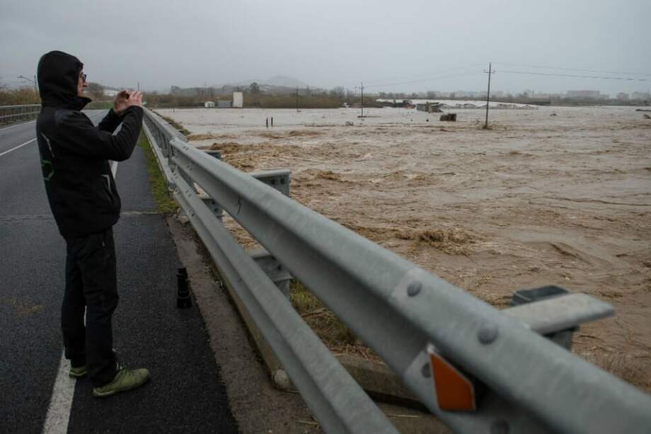 Un hombre toma una foto de los campos inundados en Malgrat de Mar, cerca de Girona, el 22 de enero de 2020, mientras la tormenta Gloria azota la costa oriental española. / AFP
