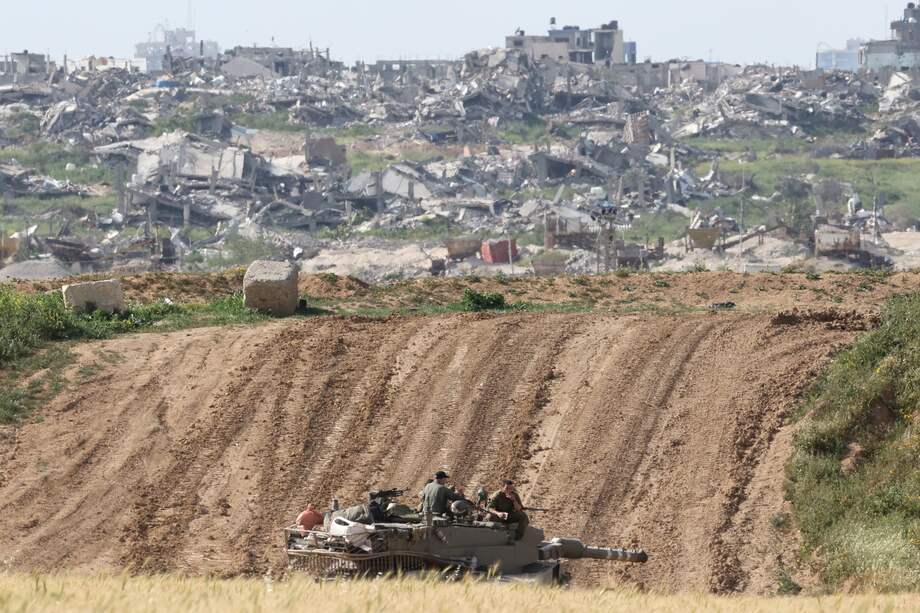 Soldados israelíes a bordo de un tanque militar transitan cerca de la valla fronteriza con la Franja de Gaza, visto desde el lado israelí en el sur de Israel, 26 de marzo de 2024.