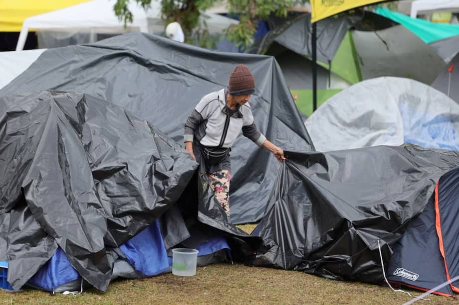 Una mujer damnificada por el terremoto de magnitud 7,4, que sacudió Colombia hace una semana, cubre sus pertenencias con plástico luego de las fuertes lluvias este lunes, en un campamento ubicado en el parque Olaya Herrera en Pereira (Colombia). EFE/Santiago Gaviria