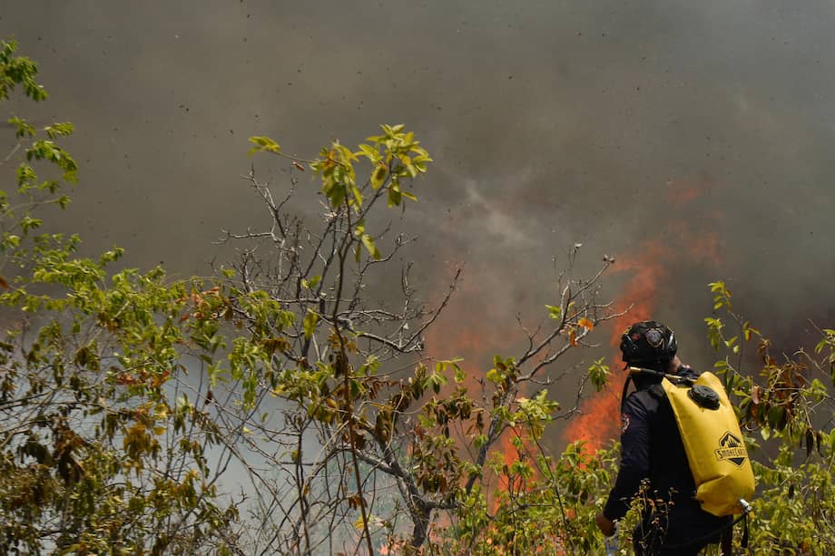 Un bombero trabaja en la contención de uno de los incendios forestales, que ya han arrasado más de 20.000 hectáreas y continúan expandiéndose, en Chagualá (Tolima).