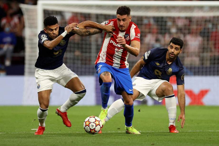 Luis Díaz (izq.), volante del Porto, disputa un balón con José Giménez, jugador del Atlético de Madrid.
