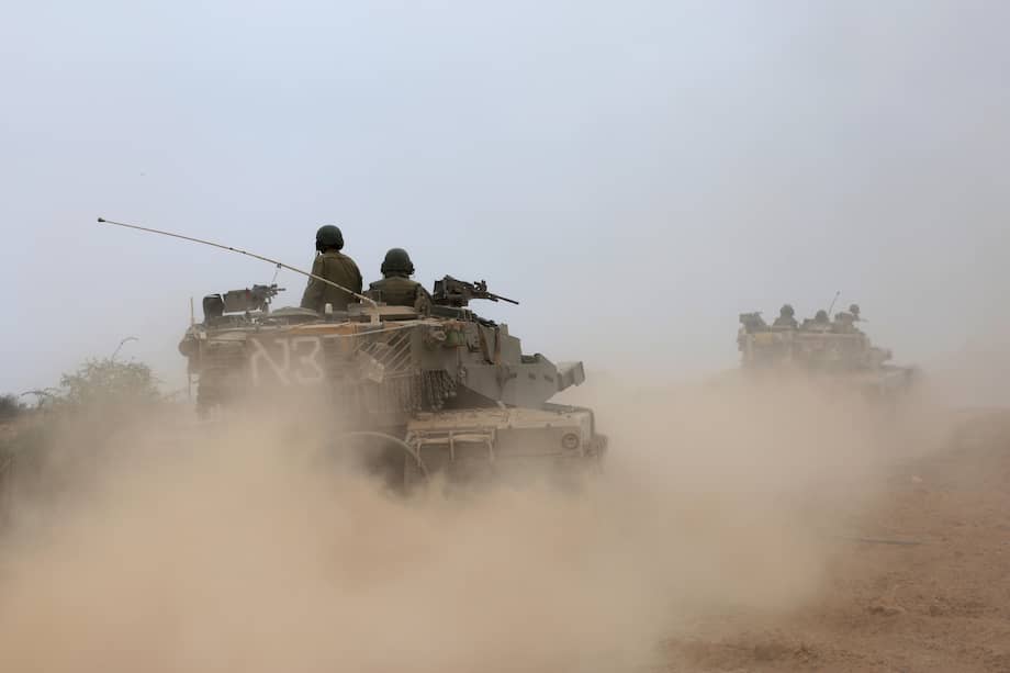 Soldados israelíes, a bordo de vehículos blindados de combate, maniobran en una zona cercana a la frontera con la Franja de Gaza.
