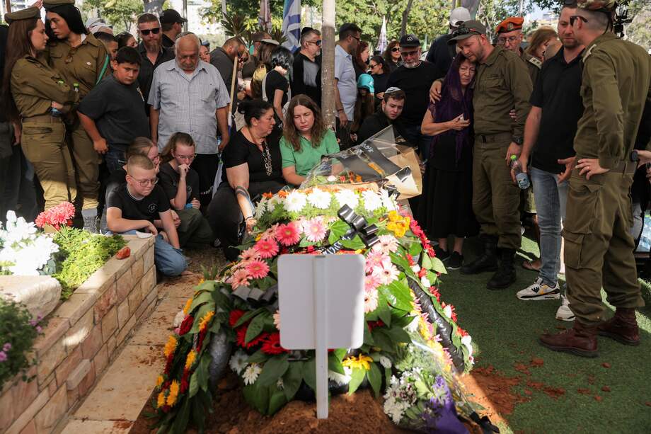 La madre (con camisa verde) del sargento del ejército israelí Yuliy Faktor, de 19 años, quien murió en combate en la Franja de Gaza, llora frente al ataúd de su hijo.