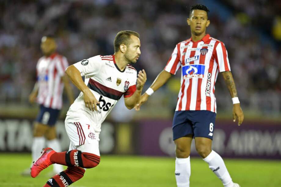 Ante la mirada de James Sánchez (Júnior), el brasileño Éverton Ribeiro celebra uno de los goles que anotó en el estadio Metropolitano Roberto Meléndez. / AFP