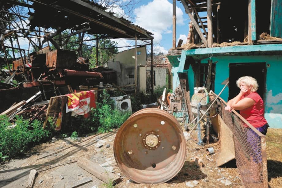 Una mujer mira después de que su casa fuera bombardeada en el pueblo de Zalissya, región de Kyiv, en medio de la invasión rusa de Ucrania.