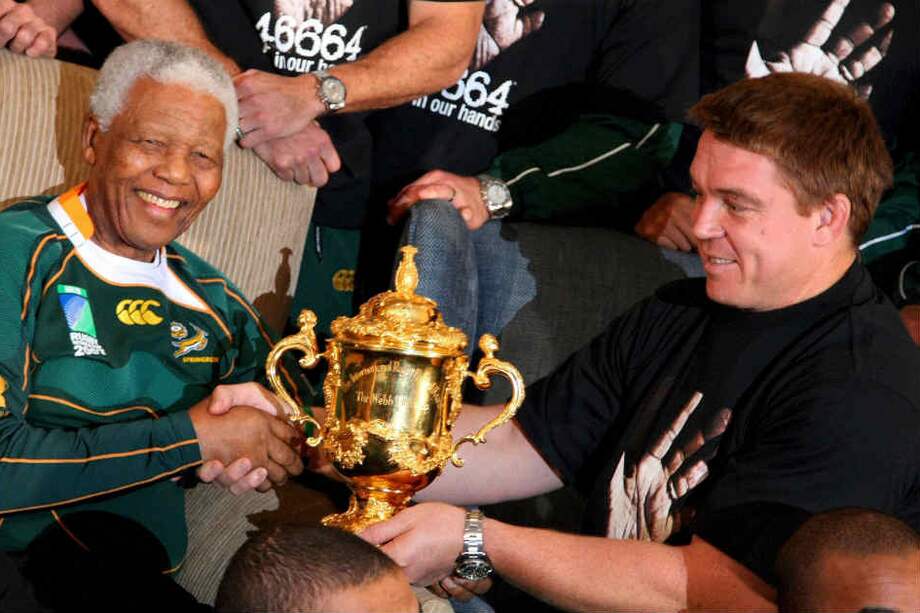 Nelson Mandela sostiene la Copa Webb Ellis con el capitán del equipo nacional Jhon Smith.