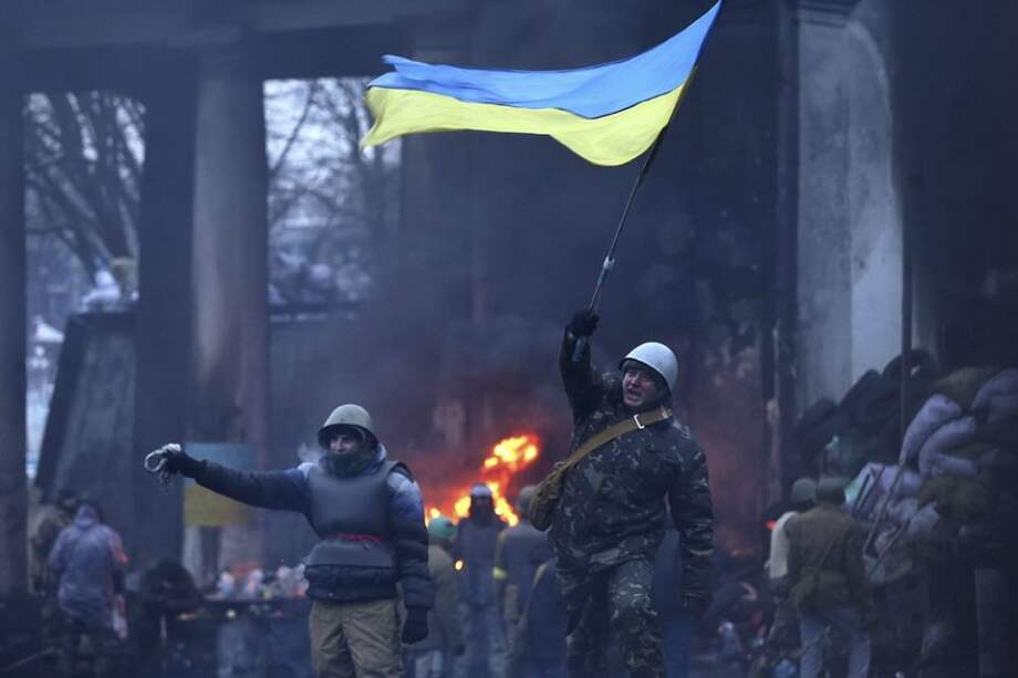 Un manifestante ondea una bandera ucraniana cerca de una barricada, durante una protesta antigubernamental en Kiev (Ucrania).
