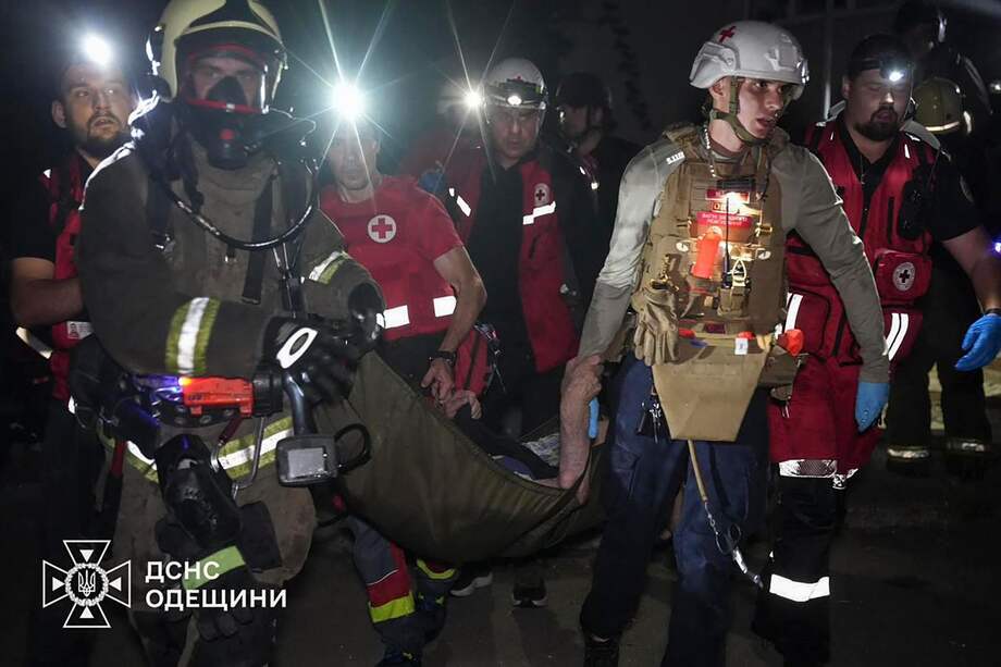 Rescatistas ucranianos llevando a una persona herida después de que un edificio residencial fuera alcanzado por un ataque con drones.