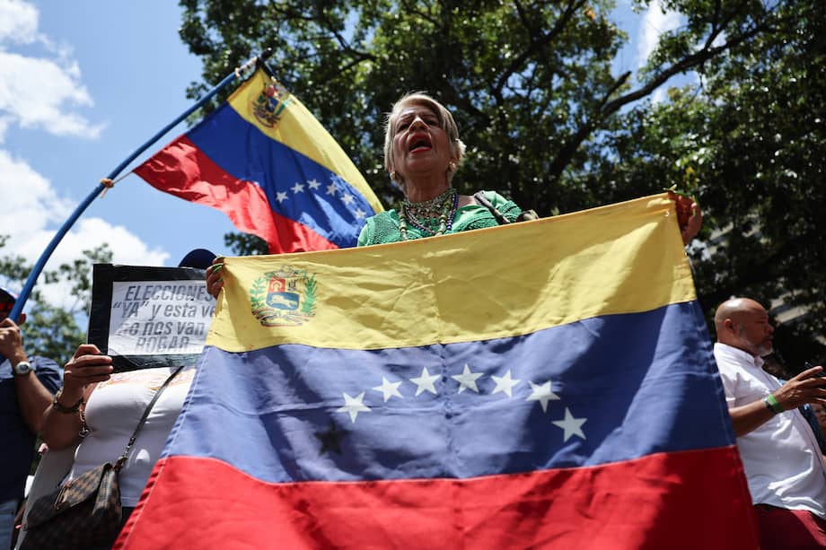 Una persona sostiene una bandera durante una manifestación este miércoles, mientras la primera ronda de negociación entre el Gobierno y la oposición de Venezuela, promovida por Estados Unidos, ocurre en el interior del hotel Meliá Caracas, en Caracas (Venezuela).