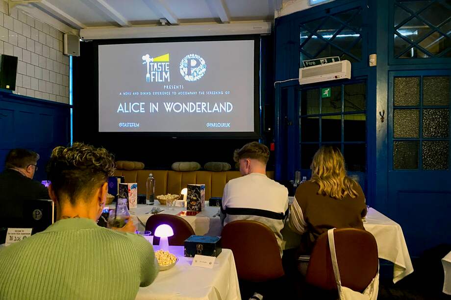 Instantes previos a la emisión de la película 'Alicia en el país de las maravillas' en un restaurante de Londres.