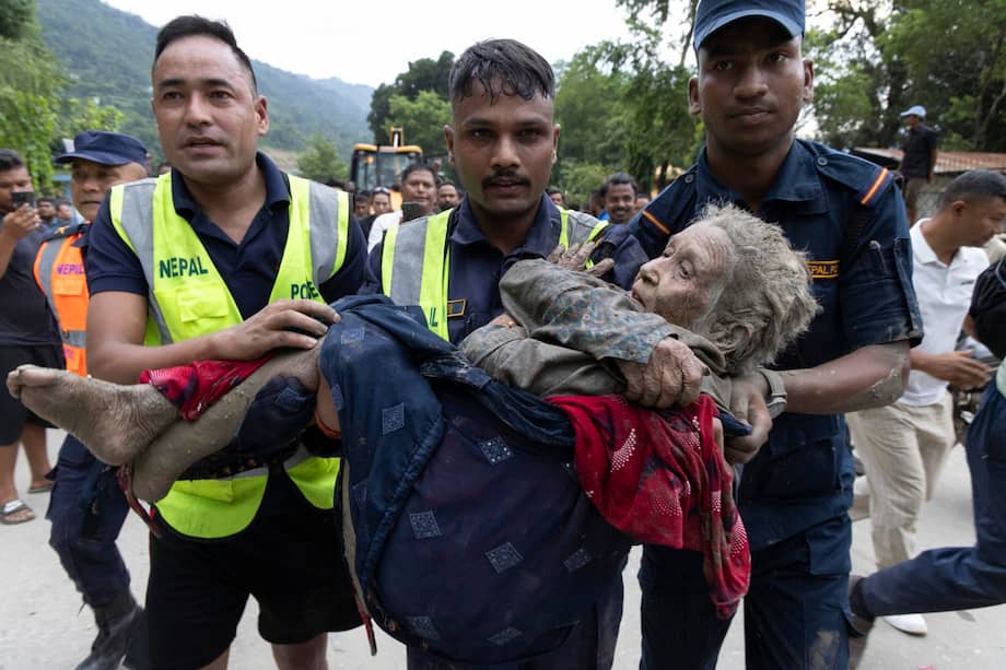 Los rescatistas trasladan a una anciana rescatada de una residencia de ancianos en Devighat tras una inundación repentina en Trishuli Bazar, Nuwakot.