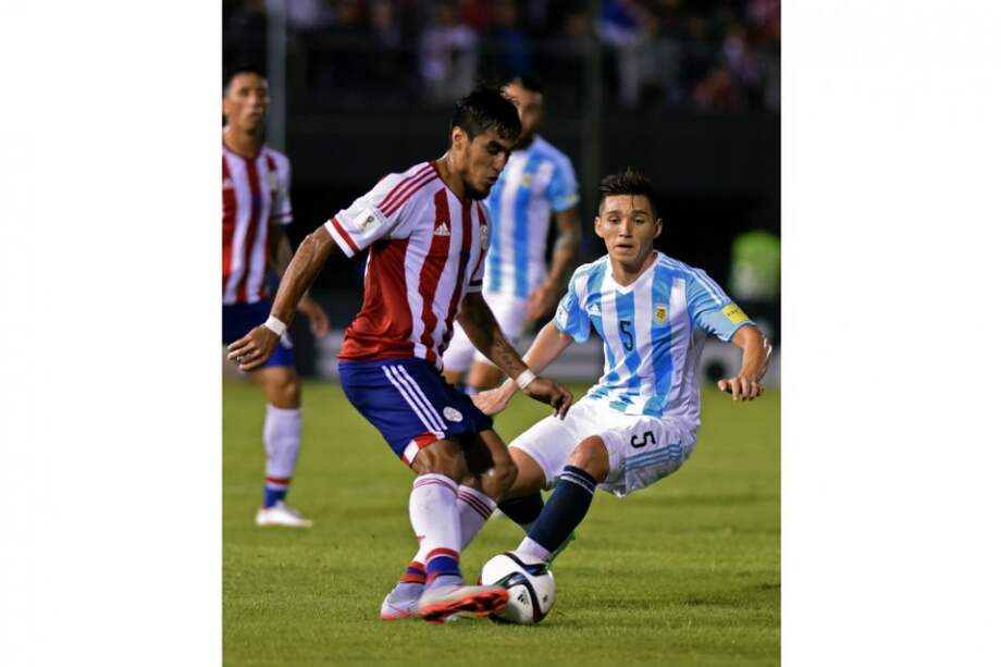 Dario Lezcano es marcado por Matias Kraneviter en el partido de la eliminatoria ante Argentina. / AFP
