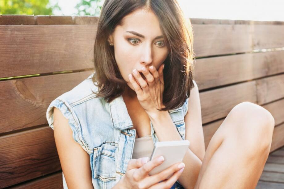 Mujer sorprendida viendo su teléfono