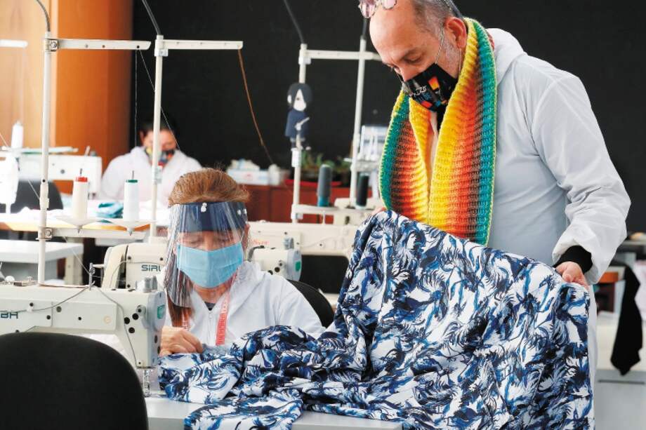 BOG413 BOGOT¡ (COLOMBIA), 28/05/2020.- FotografÌa fechada el 22 de mayo de 2020 que muestra al diseÒador colombiano Diego Guarnizo (d) mientras trabaja en una nueva colecciÛn de ropa con tela estampada antifluidos en Bogot·. La moda que siempre se ha adecuado a las crisis mediante la confecciÛn de uniformes en las guerras o las vestimentas de los mÈdicos cuando la peste negra azotÛ Europa en el siglo XIX, dice hoy "presente" desde Colombia a travÈs de ropa con la que adem·s de proteger se quiere crear una visiÛn m·s optimista frente a la pandemia del coronavirus. EFE/ Carlos OrtegaitleRef