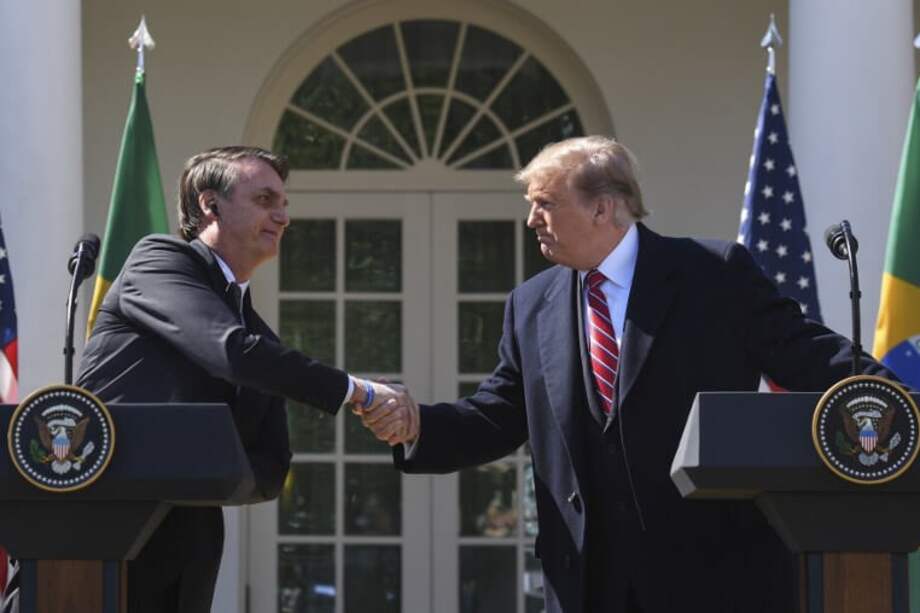 Jair Bolsonaro, presidente de Brasil, saluda a su homólogo estadounidense, Donald Trump, en Washington el 19 de marzo de 2019. / AFP