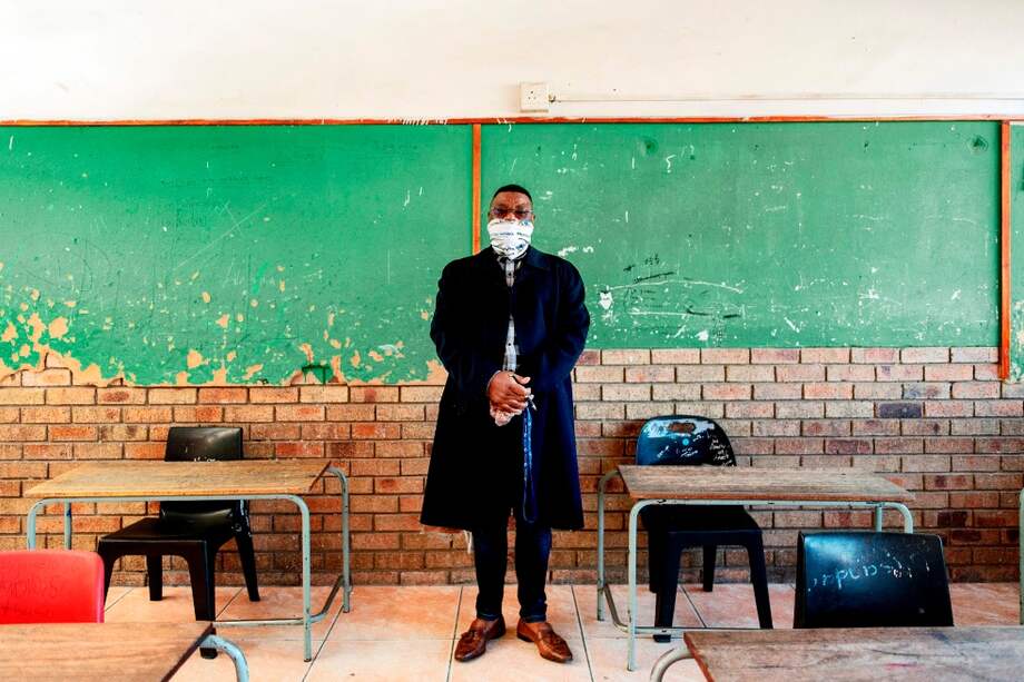 Un profesor sudafricano posa en su salón de clase, el día en que el gobierno pasó de la fase 3 de confinamiento y un Tribunal le pide revisar las medidas.