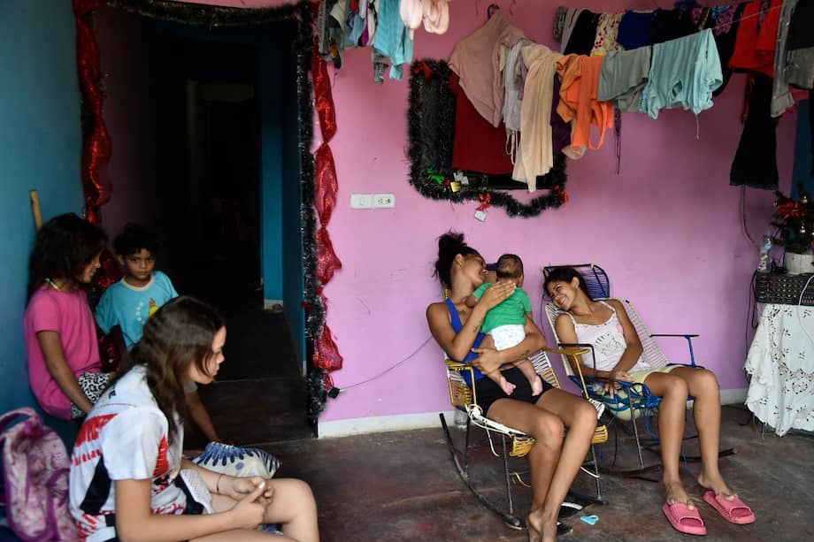 Yoamni Navarro (C), de 20 años, carga a un bebé en su casa en el asentamiento humano La Fortaleza, cerca de Cúcuta.