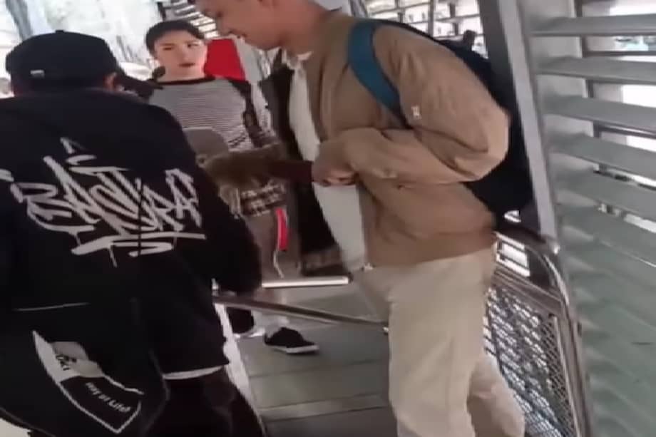 Momento en el que el sujeto de negro cobra monedas por ayudar a evadir el pasaje.
