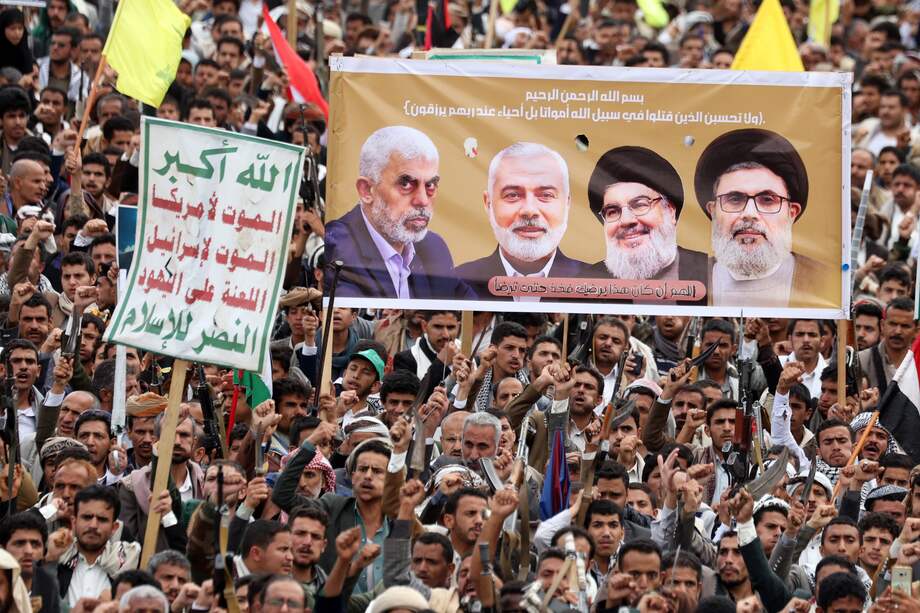 Los partidarios de Outhi sostienen una pancarta que muestra (de izq. a der.) al difunto líder de Hamás Yahya Sinwar, al difunto líder de Hamás Ismail Haniyeh, al difunto líder de Hezbolá Hassan Nasrallah y al difunto jefe del consejo ejecutivo de Hezbolá Hashem Safieddine