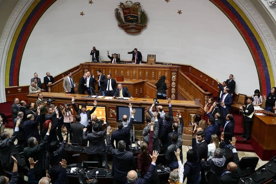Diputados opositores levantan la mano para votar a favor de la reforma parcial del reglamento interior y debate durante la sesión extraordinaria de la Asamblea Nacional el martes 17 de diciembre. / EFE