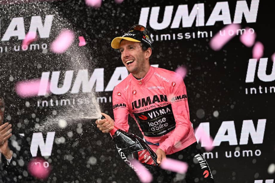 Simon Yates celebrando en el podio con la maglia rosa de líder del Giro de Italia 2025.