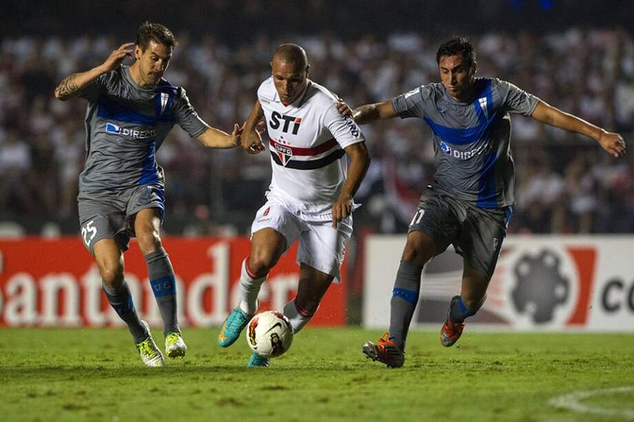 Luis Fabiano pelea la pelota con Tomas Costa y Hans Martínez de Universidad Católica