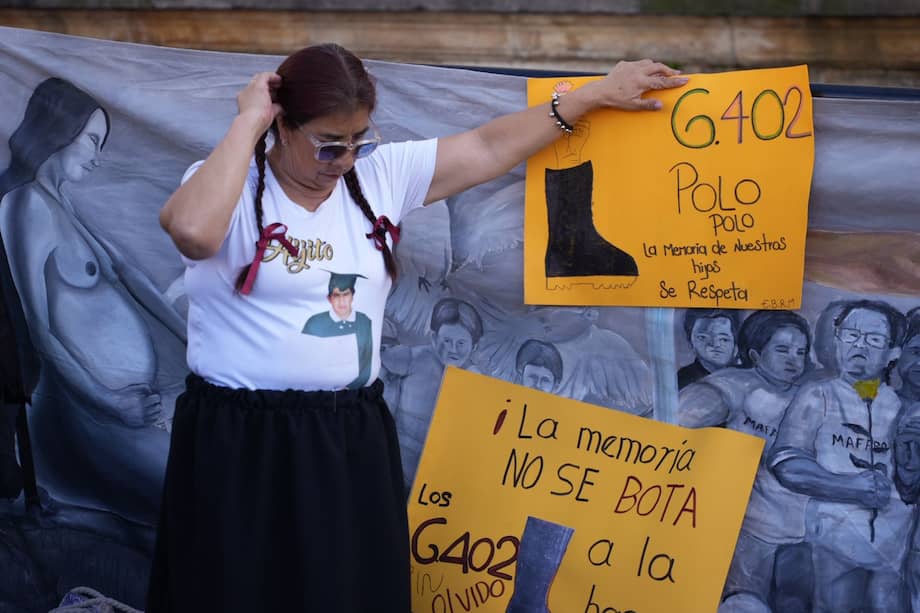 Una de las madres de las víctimas de falsos positivos sostiene uno de los carteles que se llevaron a la actividad.