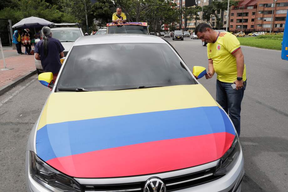 AME1805. BOGOTÁ (COLOMBIA), 14/07/2024.- Un aficionado de la selección colombiana de fútbol adorna su carro con la bandera de Colombia, este domingo Bogotá (Colombia). Los colombianos amanecieron este domingo envueltos en su bandera e ilusionados con la posibilidad de que su selección de fútbol derrote a Argentina en la final de la Copa América y regrese al país desde Miami con el trofeo en el equipaje. EFE/ Carlos Ortega