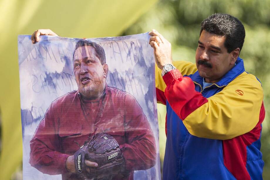 El presidente de Venezuela, Nicolás Maduro, en el Palacio de Miraflores, con una imagen del fallecido presidente Hugo Chávez. / EFE
