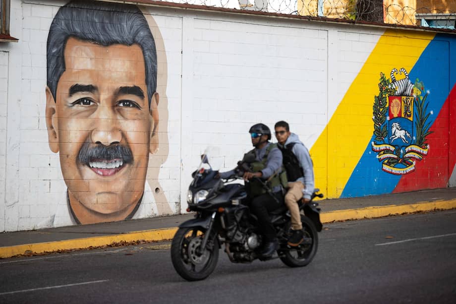 Personas transitan frente a un mural del presidente de Venezuela, Nicolás Maduro, este domingo en Caracas (Venezuela).
