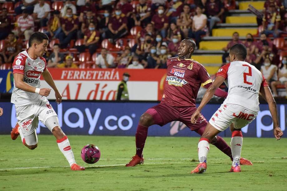 Juan Fernando Caicedo (Tolima) busca mantener la posesión del balón ante la marca de los defensas de Santa Fe.
