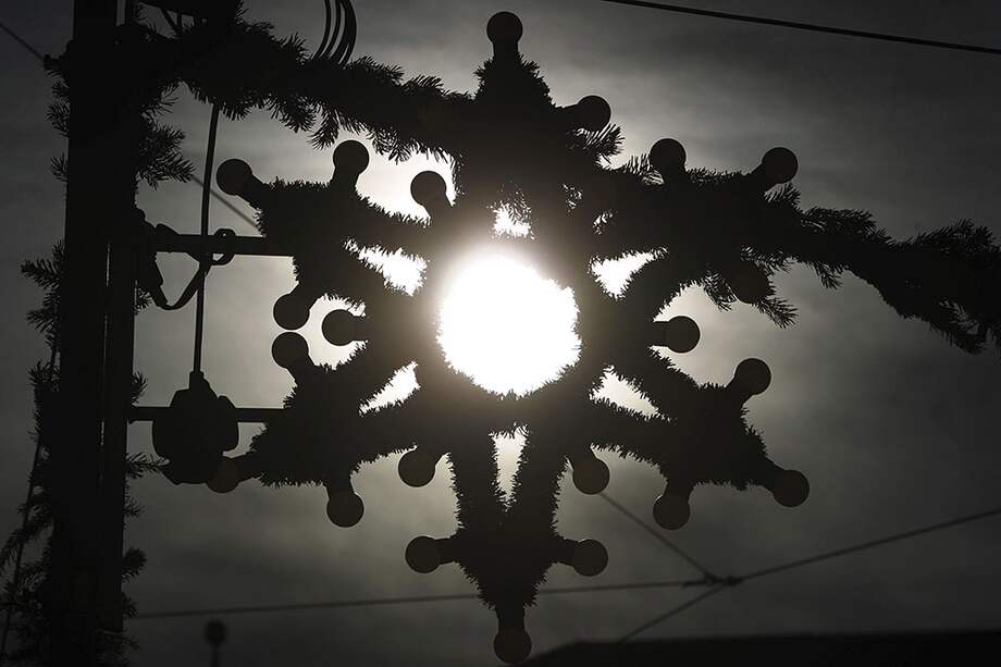 Una estrella navideña a contraluz en un mercado de Navidad en Augsburgo (Alemania). / EFE