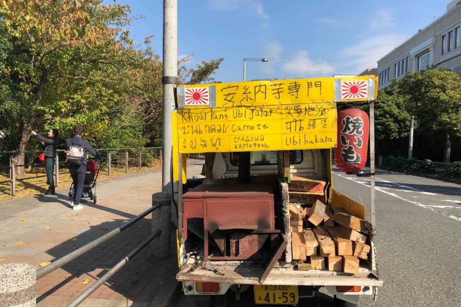 Venta ambulante de batata asada, con cartel en nueve idiomas, en el barrio de Odaiba en Tokio.
