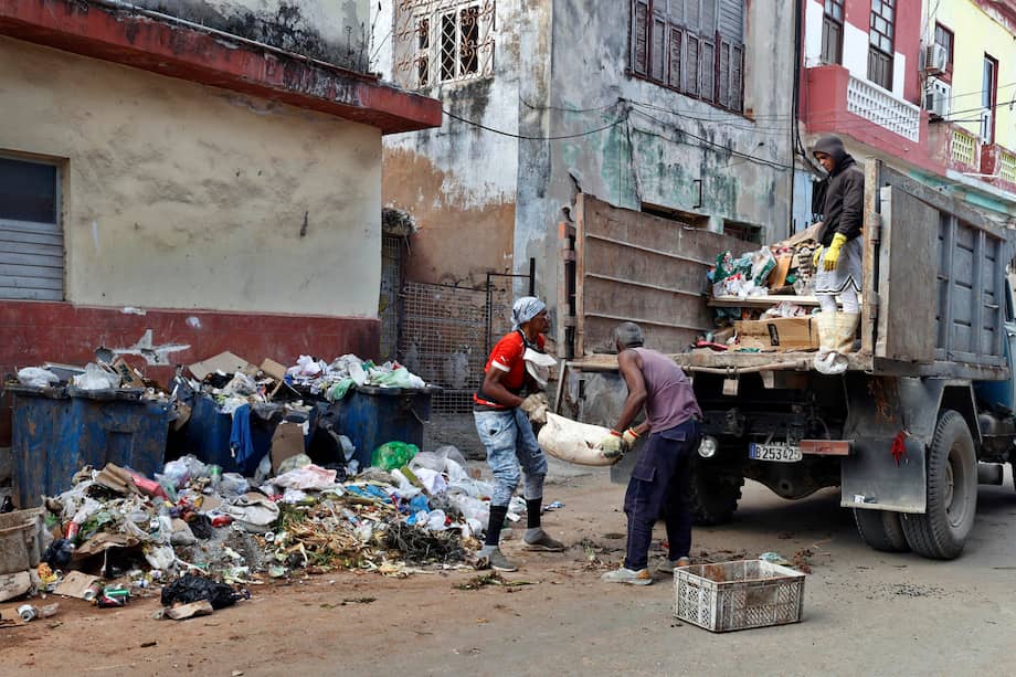 Personas recogen basura este jueves, en una calle de La Habana (Cuba).