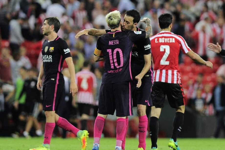 Lionel Messi y Sergio Busquets, futbolistas de Barcelona, se abrazan tras vencer 0-1 al Athletic. / AFP
