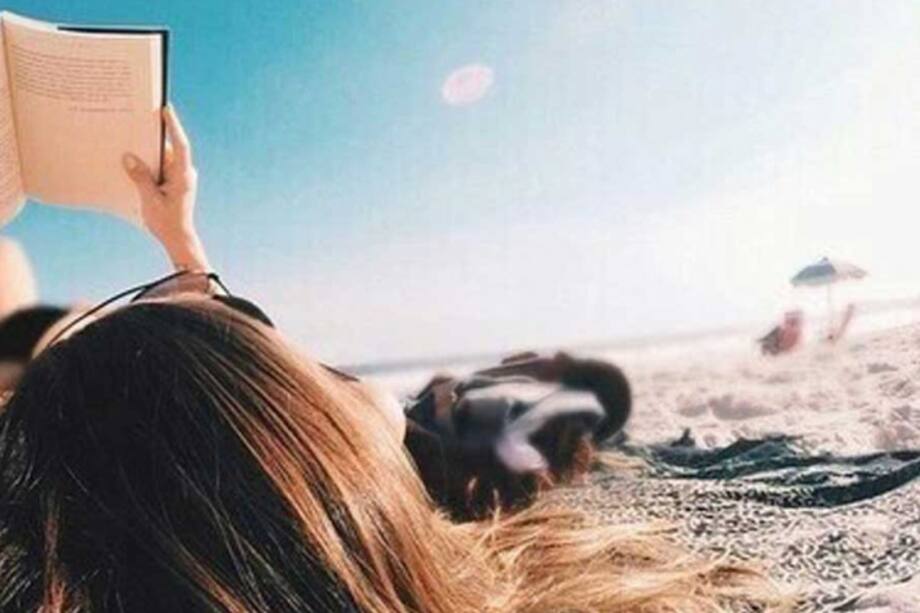 Mujer leyendo un libro en la playa